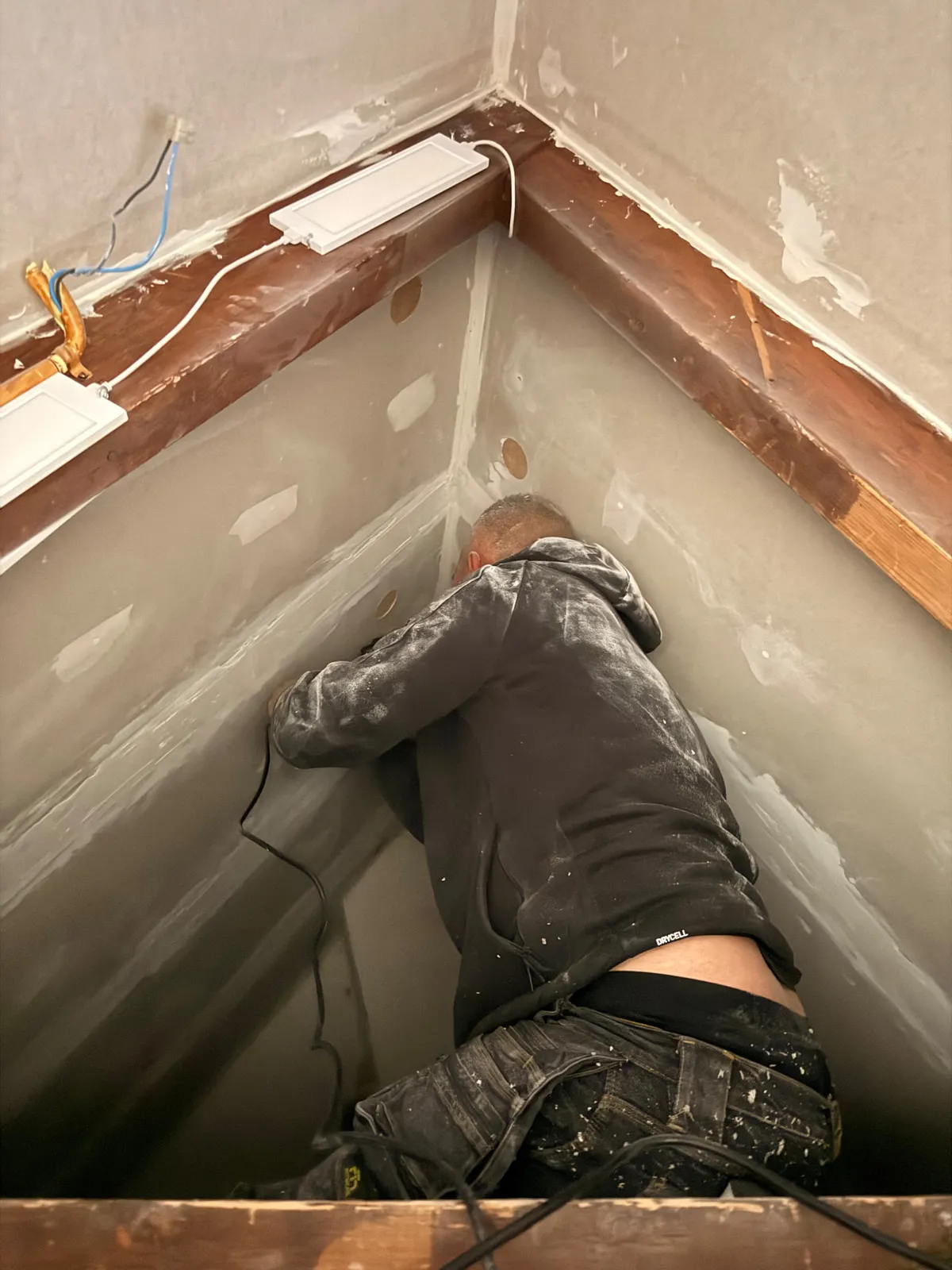 Vakman werkt inblaasgaten af in een schuine dakconstructie na het inblazen van isolatie